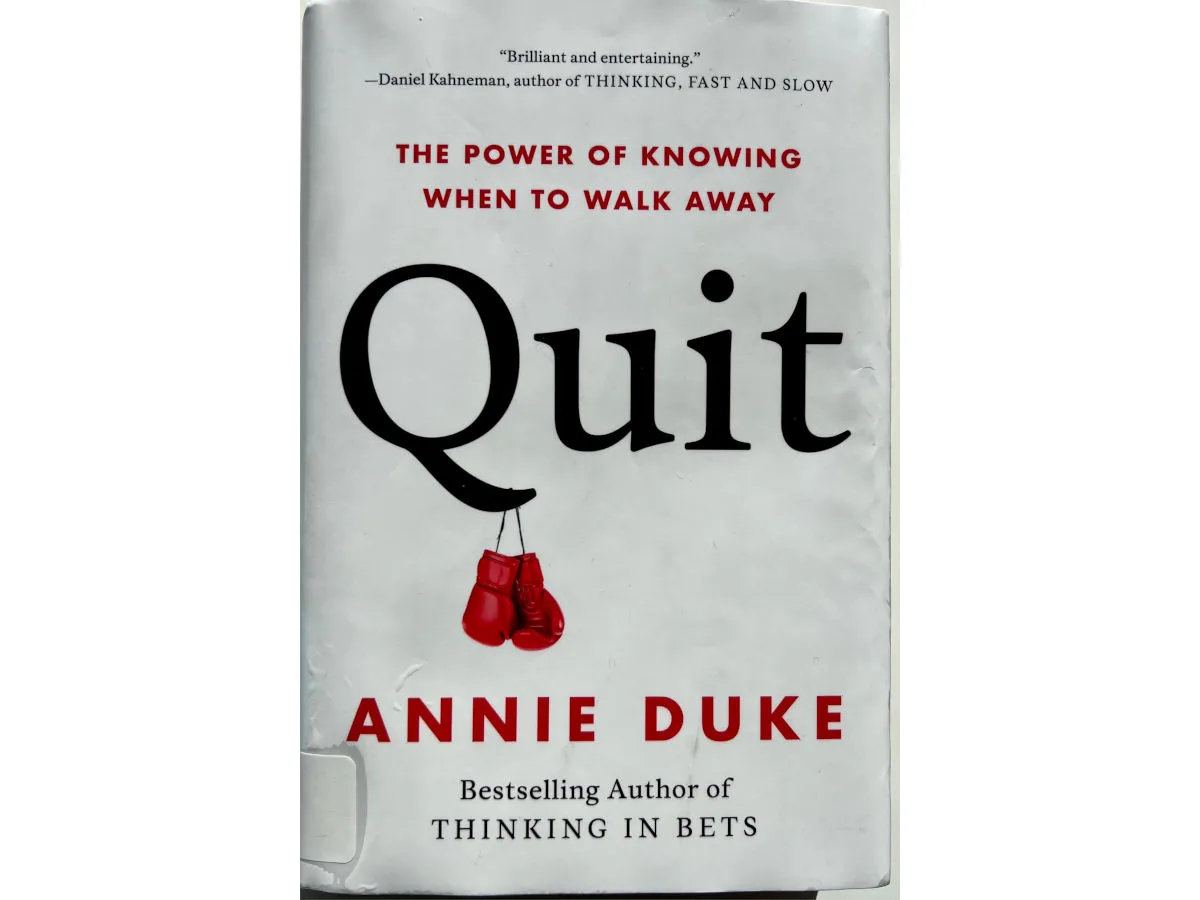 White cover of Quit by Annie Duke with red boxing gloves hanging from the title